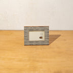 Striped wooden photo frame displayed horizontally on a table