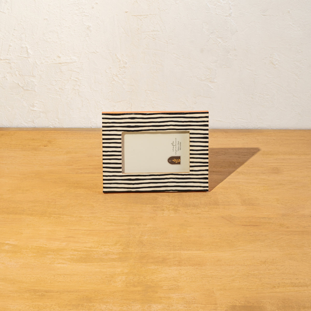 Striped wooden photo frame displayed horizontally on a table