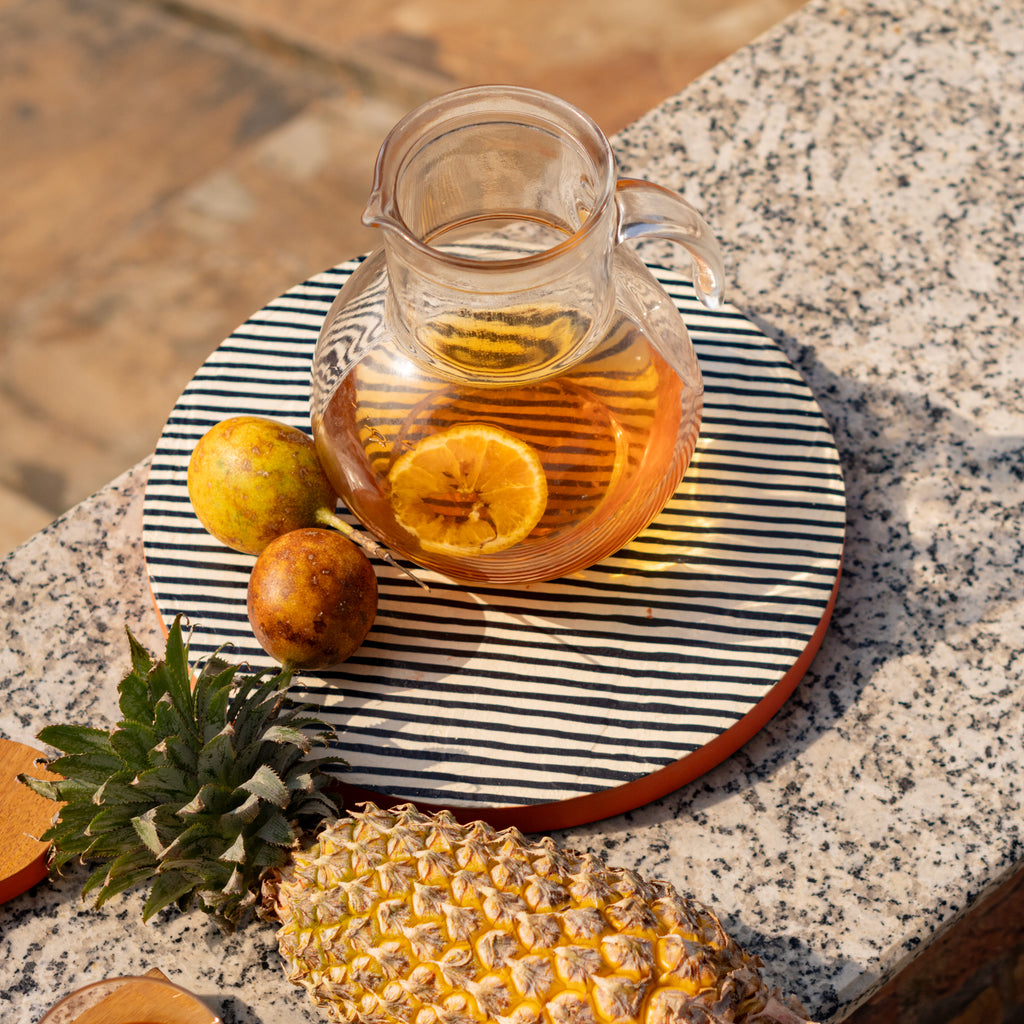 Striped wooden platter set styled with tableware and fruit