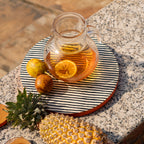 Striped wooden platter set styled with tableware and fruit