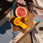 Wavy wooden cake stand styled with fruit on a table