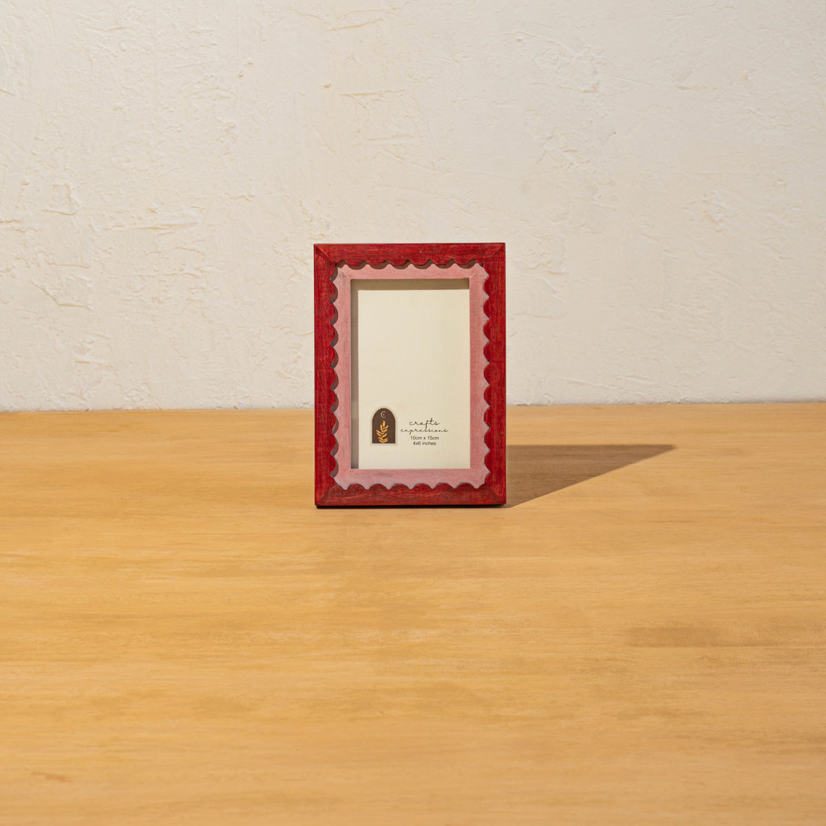 Red wavy wooden photo frame standing upright on a table