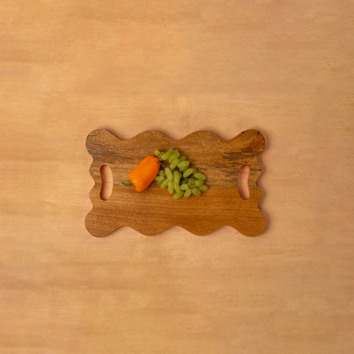 Wavy wooden platter styled with vegetables and fruit