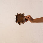 Wavy wooden spoon rest held in one hand