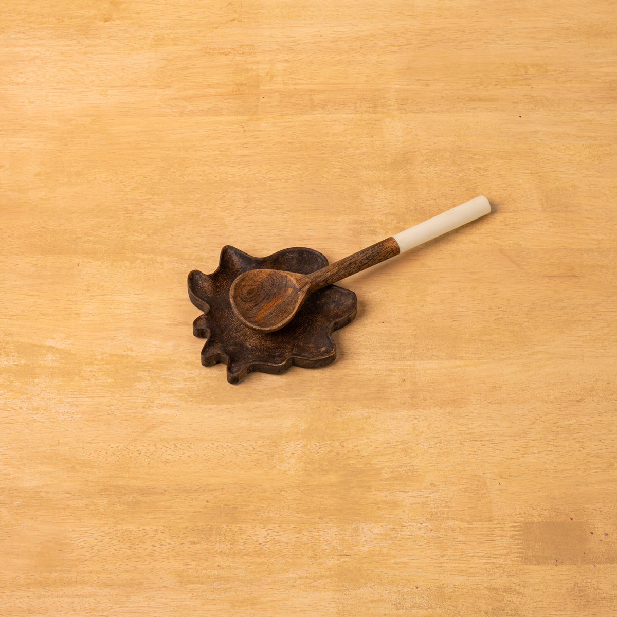 Wavy wooden spoon rest displayed with a spoon